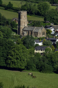View over fields and trees towards the village of Huish Champflower.