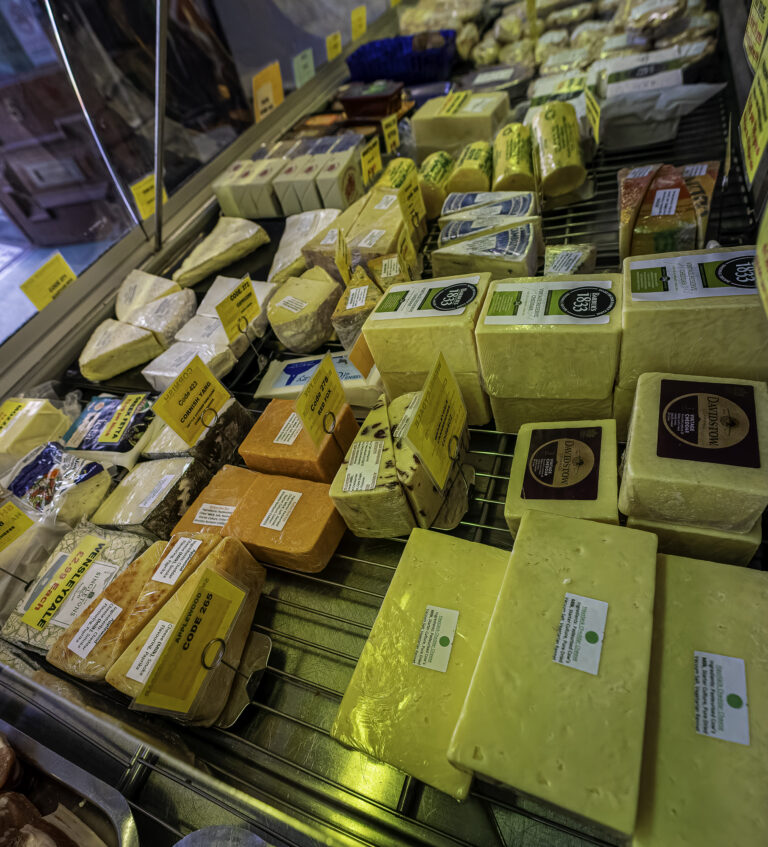 Extensive cheese display inside butcher's