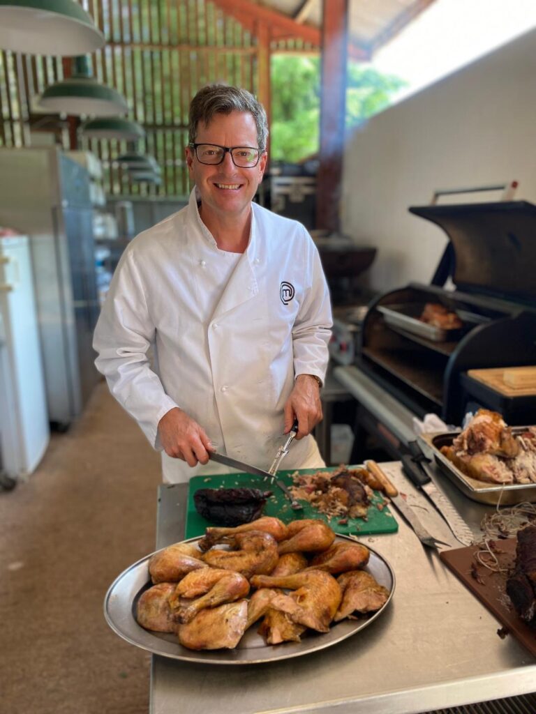 Picture of William Sitwell cutting up chicken pieces in a commercial kitchen.